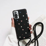 a woman holding a phone case with hearts on it