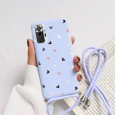 a woman holding a phone case with hearts on it