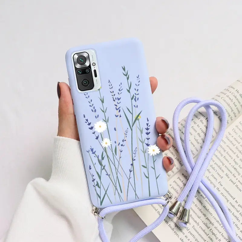 a woman holding a phone case with flowers on it