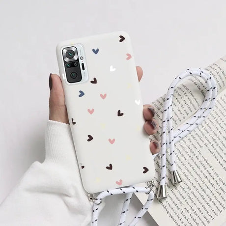 a woman holding a phone case with hearts on it