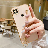 a woman holding a phone case with a heart charm