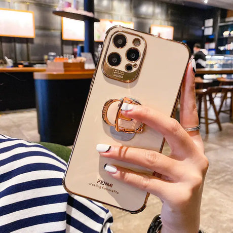 a woman holding a phone case with a ring on it