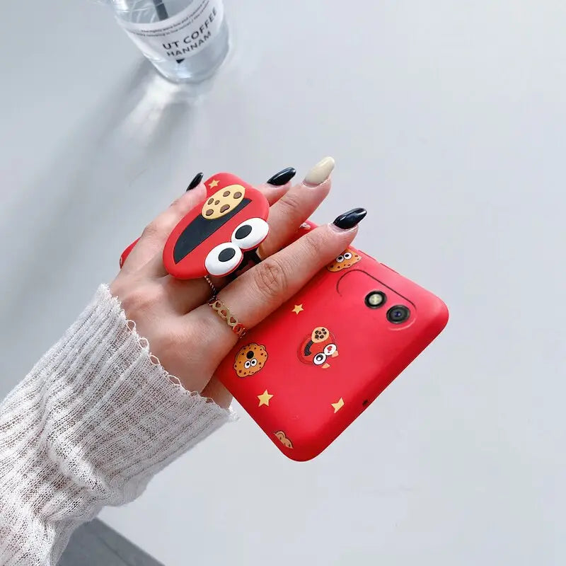 a woman holding a red phone case with a cartoon face on it