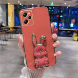a woman holding a phone case with a pink bunny