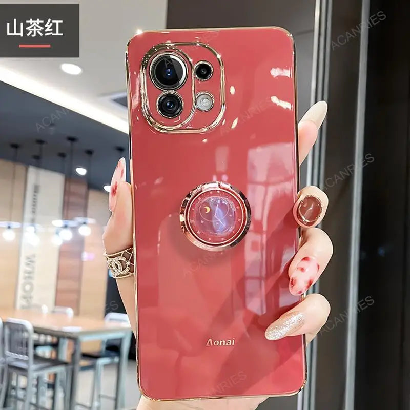 a woman holding a red phone case with a ring