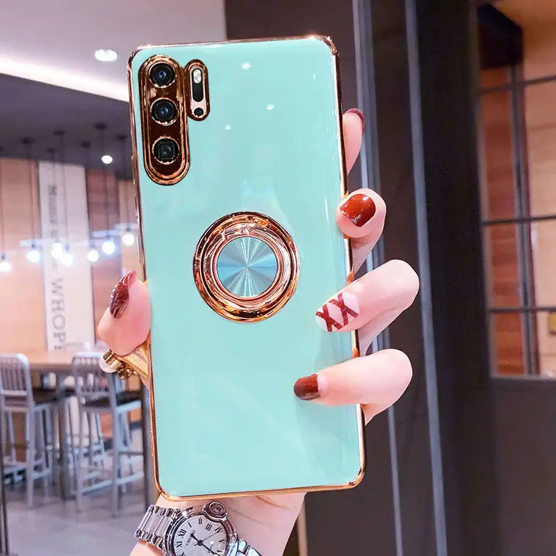 a woman holding a phone case with a ring on it