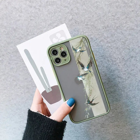 a woman holding a phone case with a bird print