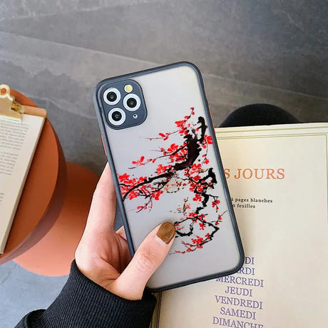 a woman holding a phone case with a red flower on it