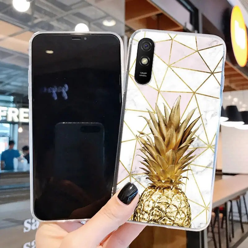 a hand holding a phone case with a gold pine