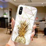 a person holding a phone case with a gold pine