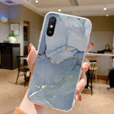 a person holding up a phone case with a marble pattern