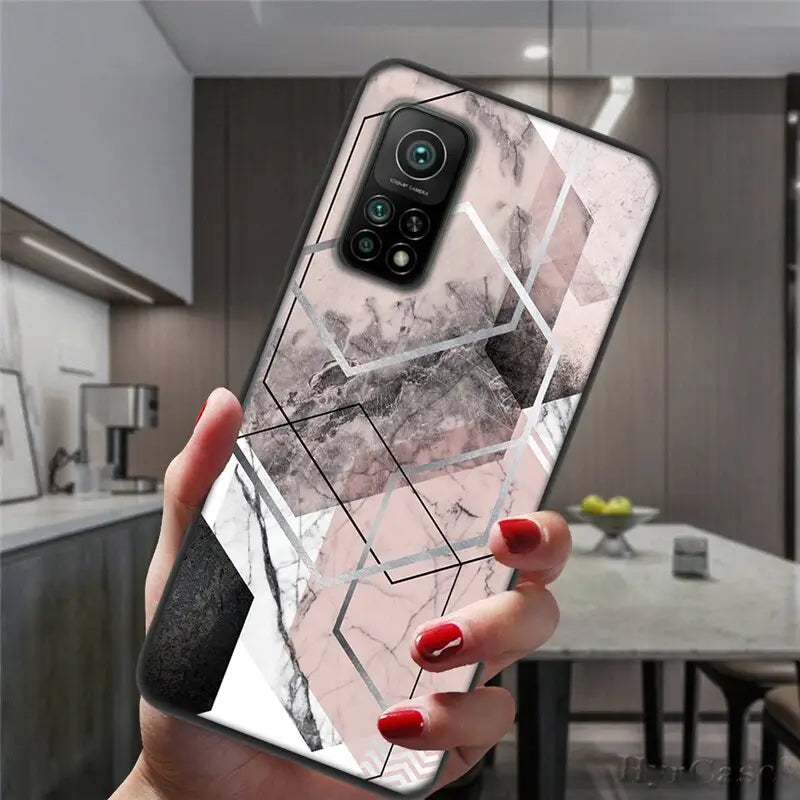 a woman holding a phone case with a marble pattern