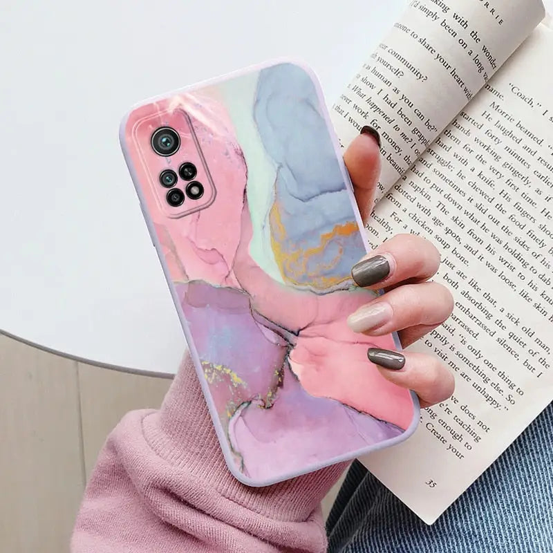 a woman holding a book and holding a phone case