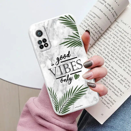 a woman holding a phone case with the words vibes on it