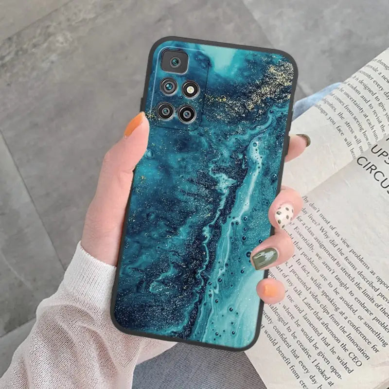 a woman holding a phone case with a blue marble pattern