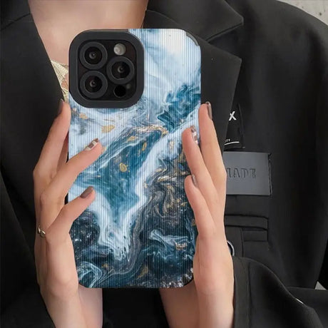 a woman holding a phone case with a marble pattern