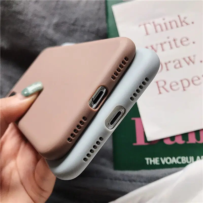 the back of a woman’s hand holding a pink iphone case