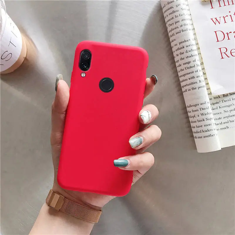 a woman holding a red phone case