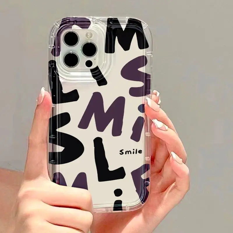 a woman holding a phone case with a black and white pattern