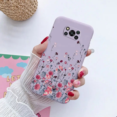 a woman holding a phone case with flowers on it