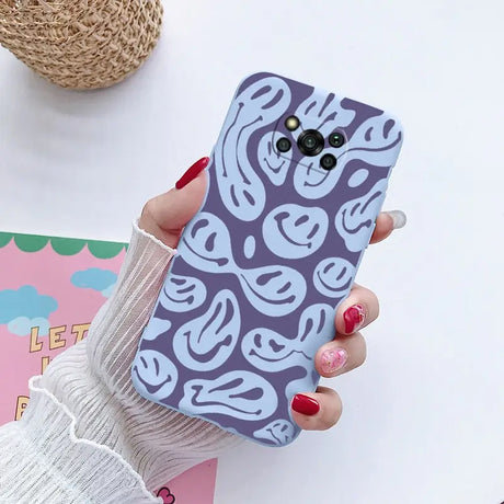 a woman holding a phone case with a pattern on it