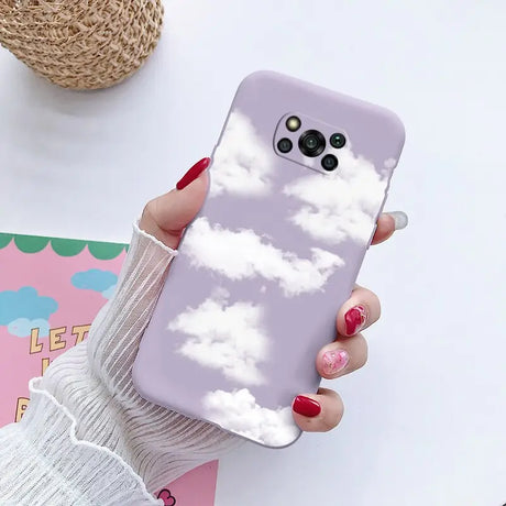 a woman holding a phone case with clouds on it