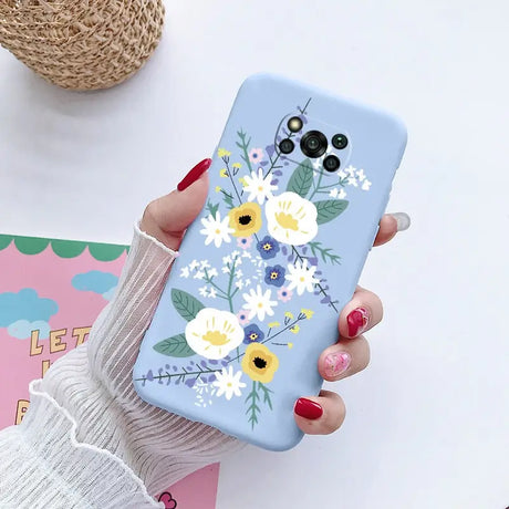 a woman holding a phone case with flowers on it