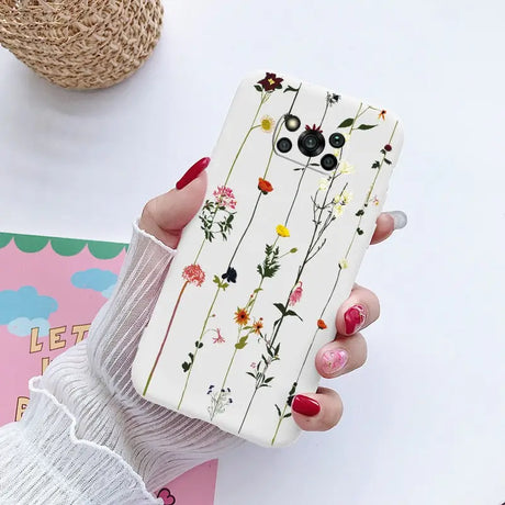 a woman holding a phone case with flowers on it