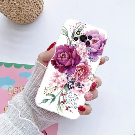 a woman holding a phone case with flowers on it