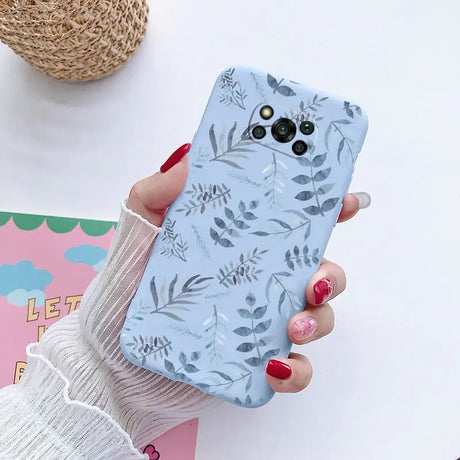 a woman holding a phone case with a floral pattern