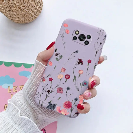 a woman holding a phone case with flowers on it