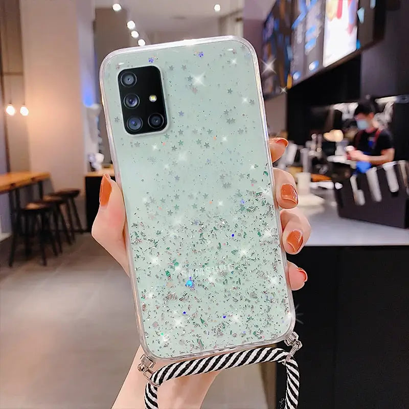 a woman holding a phone case with glitter stars on it