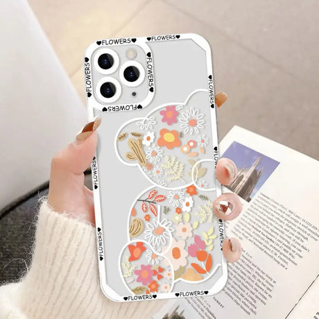 a woman holding a phone case with flowers on it