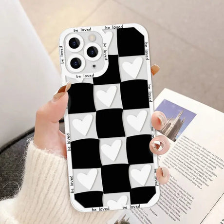 a woman holding a phone case with a heart pattern