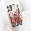 a woman holding a phone case with flowers on it