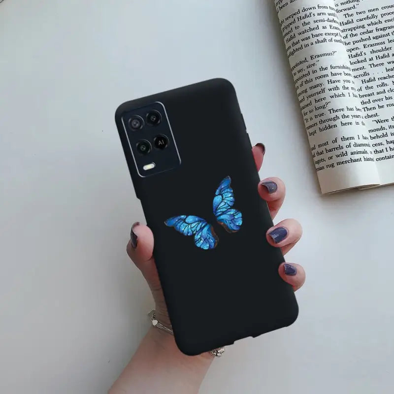 a woman holding a phone case with a blue butterfly on it