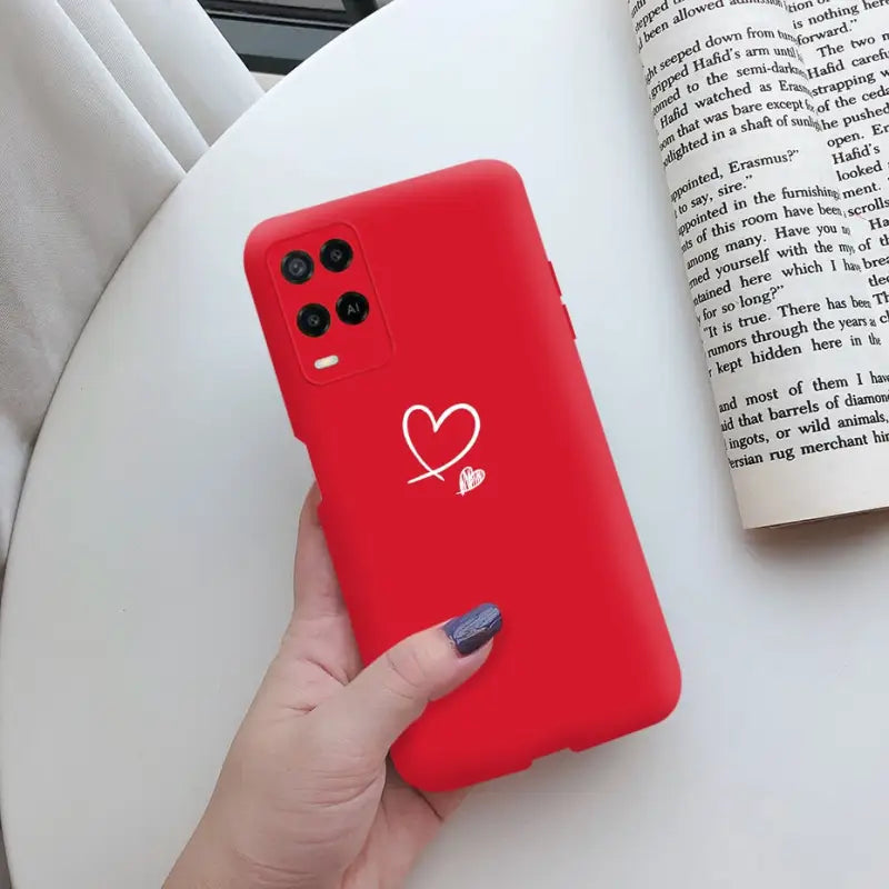 a woman holding a red phone case with a heart on it