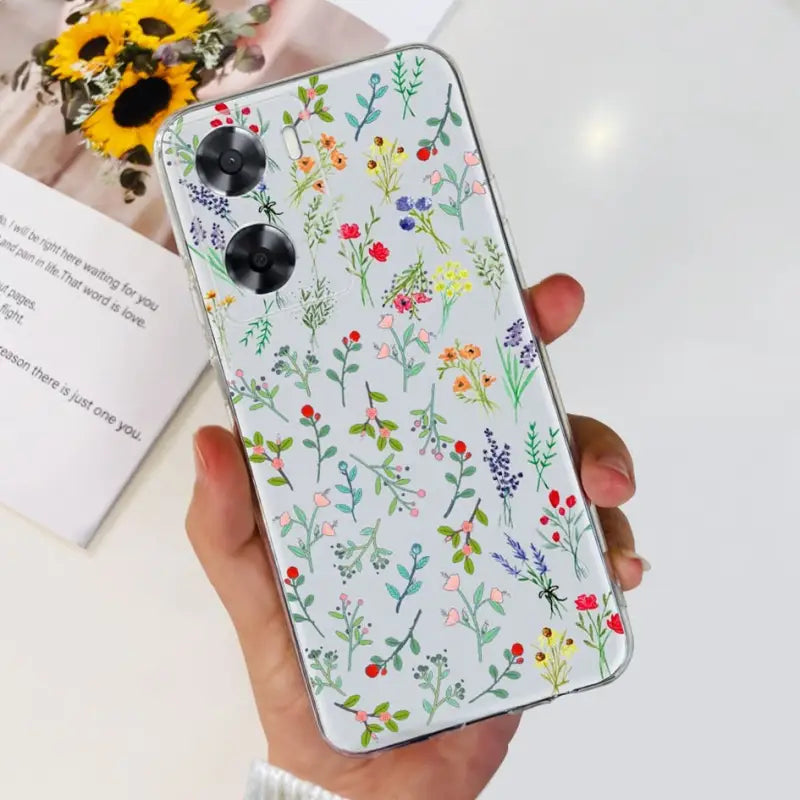 a woman holding a phone case with flowers on it