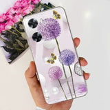 a hand holding a clear phone case with purple flowers
