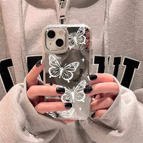 a woman holding a phone case with butterflies on it