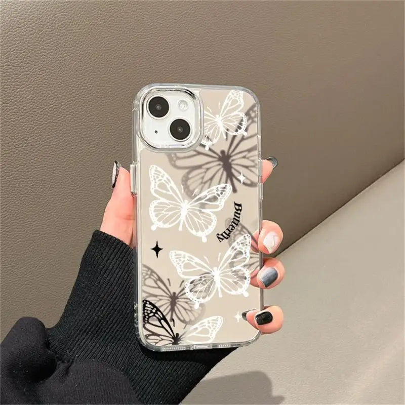 a woman holding a phone case with a white flower design