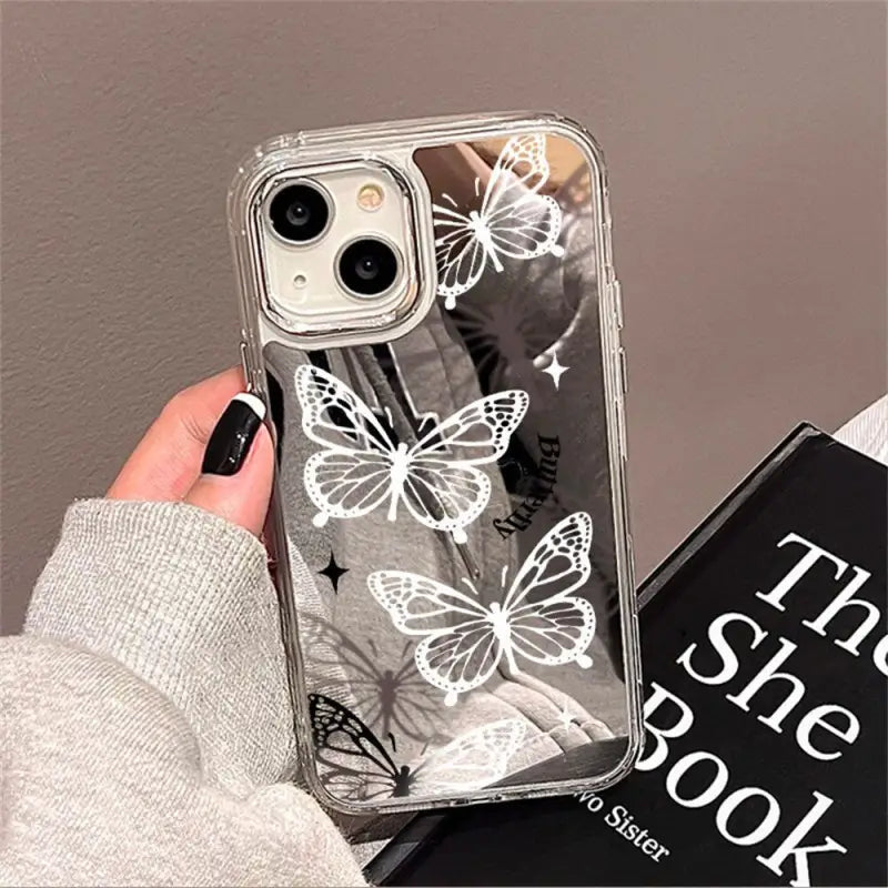 a person holding a phone case with a white butterfly design