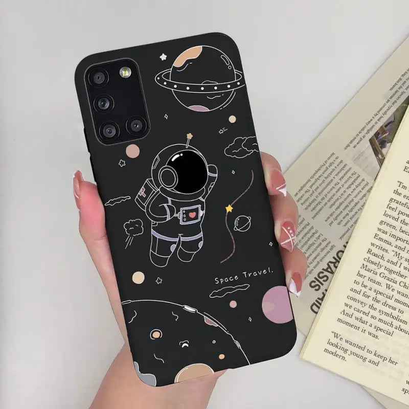 a woman holding a phone case with an astronaut and planets pattern