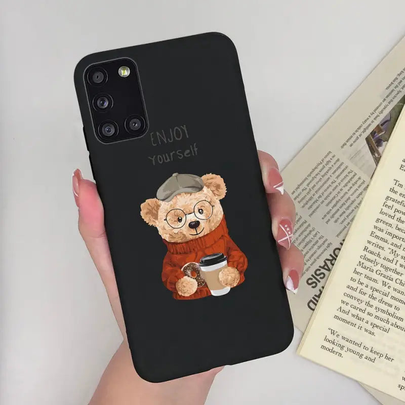a woman holding a phone case with a bear