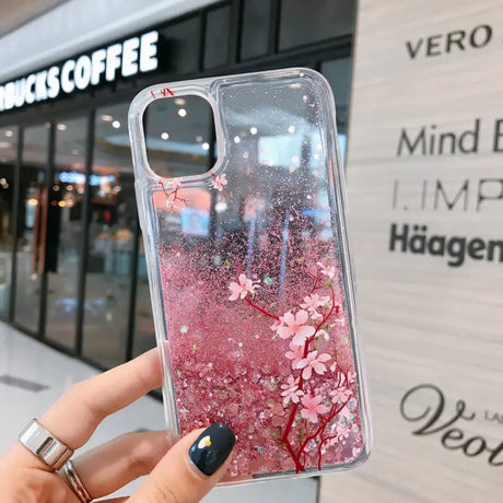 a woman holding a phone case with pink flowers on it