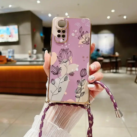 a woman holding a phone case with flowers on it