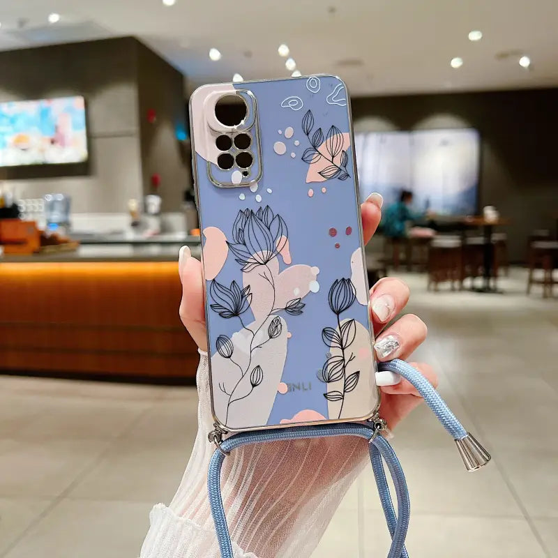 a woman holding a phone case with a blue floral pattern