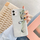 a woman holding a phone case with a bird on it