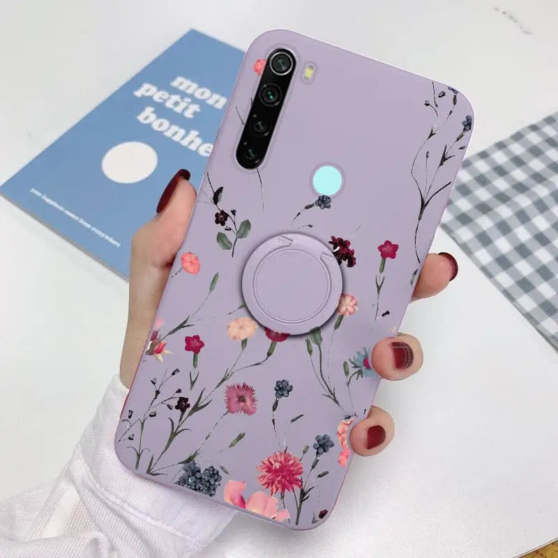 a woman holding a phone case with flowers on it