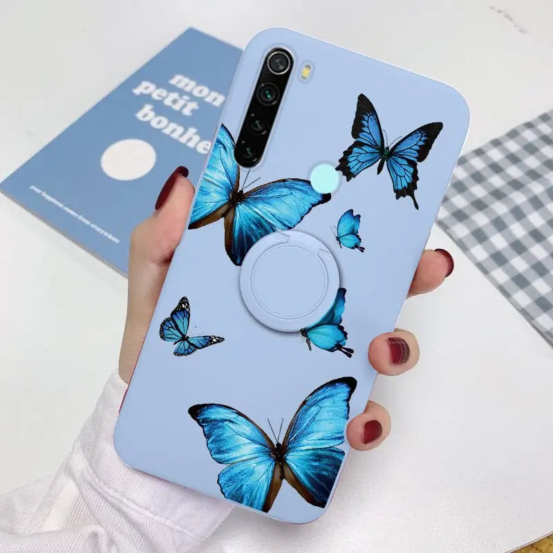 a woman holding a phone case with blue butterflies on it